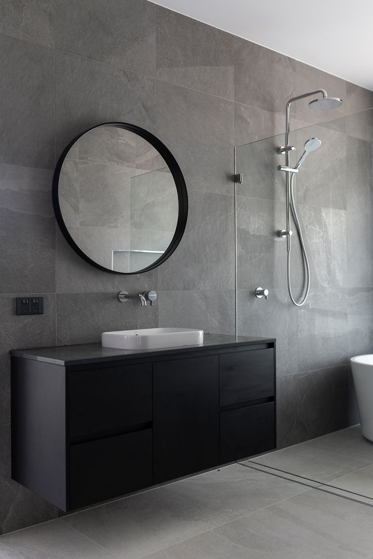 a bathroom with a sink, mirror and bathtub next to a window on the wall