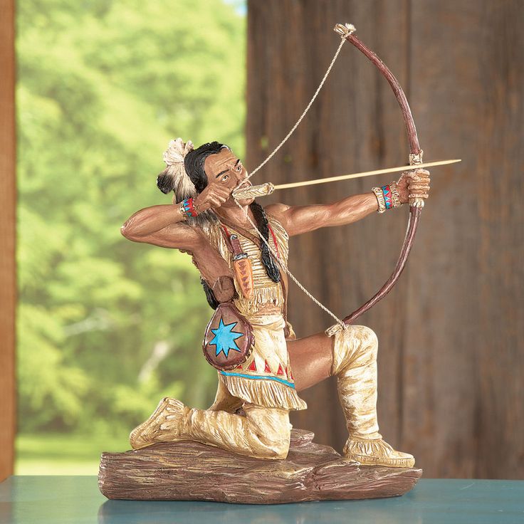 a figurine of a native american man with a bow and arrow on a table