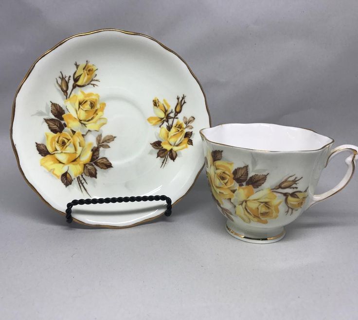 two porcelain cups and saucers with yellow roses on them