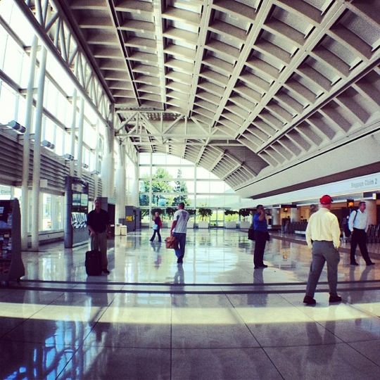 several people are walking through an airport terminal