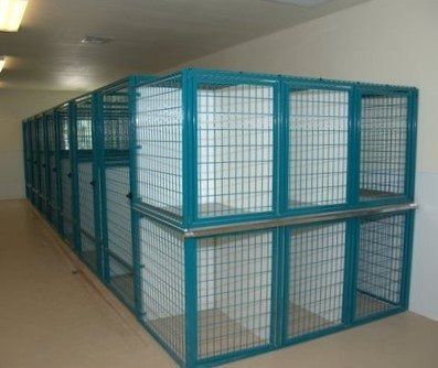 several cages are stacked on top of each other in an empty room with white walls