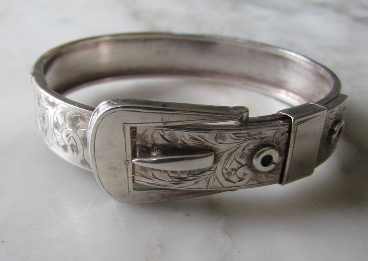 Bangle  Code AA1E A Beautiful  Sterling Silver Bangle in an engraved Buckle Design with a plain back  Width 1.2cms Wide - 6cms inside closed wide - I Have a 16.5cms wrist and it fits me just right  Approx 19gms  In Good Condition  Stamped  " Chester 1938 JH&S " Other Bracelets not included Ornate Stamped Bracelets For Formal Occasions, Antique Stamped Cuff Bracelet For Formal Occasions, Antique Engraved Cuff Bracelet For Formal Occasions, Adjustable Antique Sterling Silver Bracelet, Vintage Bangle Jewelry With Engraving Option, Antique Engraved Sterling Silver Bracelet For Formal Events, Vintage Bangle With Engraving Option, Victorian Sterling Silver Bracelet, Engraved For Formal Occasions, Adjustable Engraved Victorian Bangle