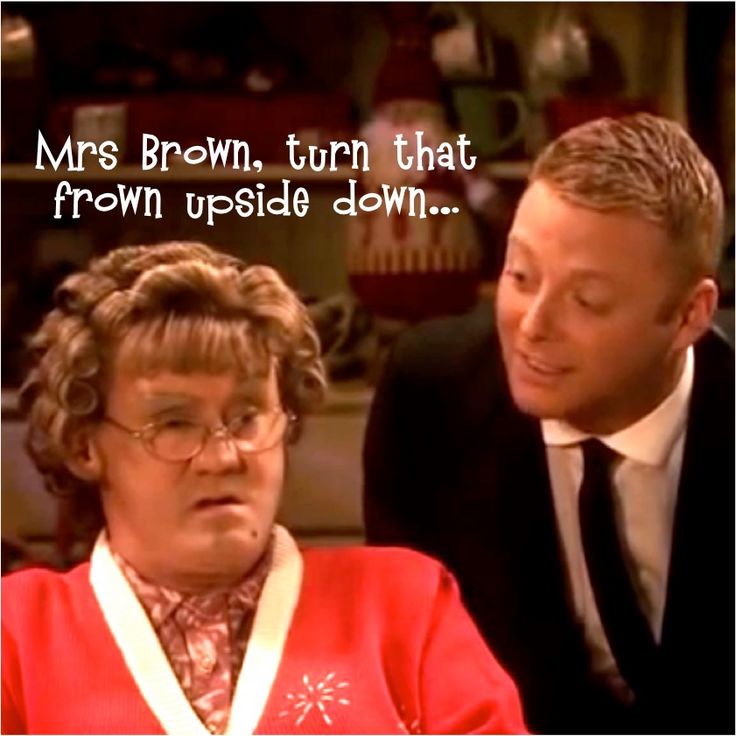 a man and woman sitting next to each other in front of a sign that says mrs brown, turn that frown upside down