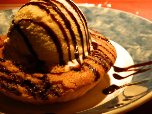 an ice cream sundae on a plate with chocolate drizzle