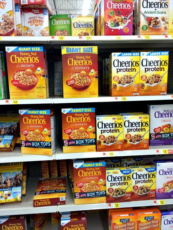 cereals are on display for sale in a grocery store's shelves, with the price tag below them