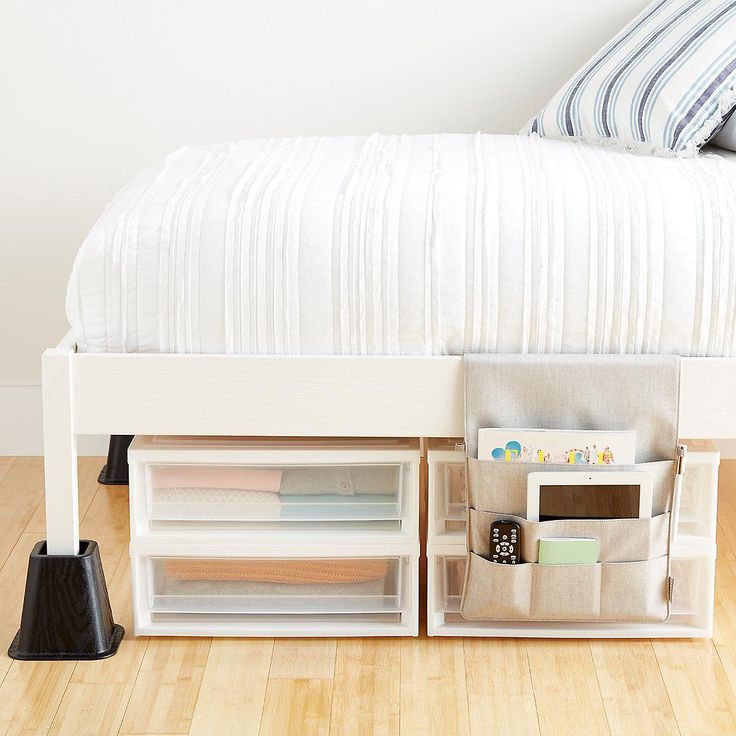 a white bed with two storage bins underneath it