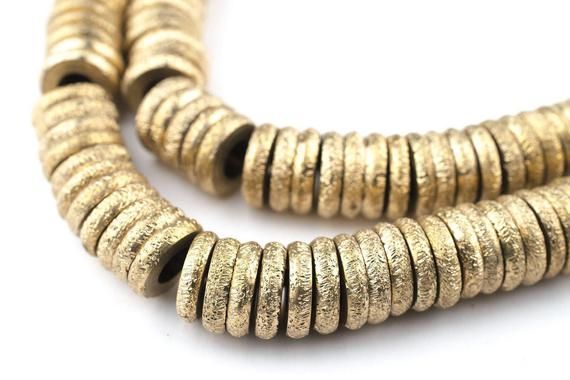 two strands of gold colored metal beads on a white background with clippings to the side