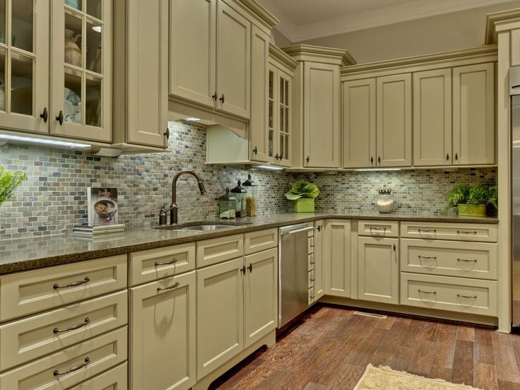 a large kitchen with beige cabinets and wood flooring, along with a stainless steel refrigerator freezer