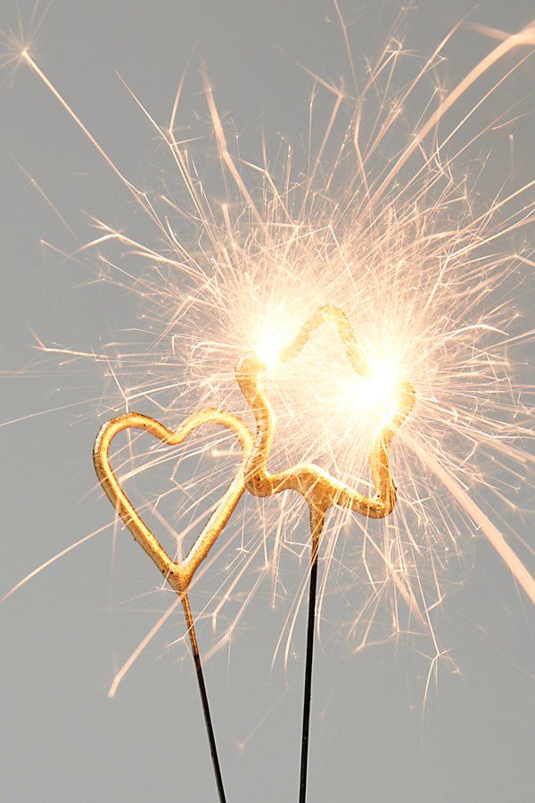 two sparklers shaped like hearts on top of each other with the sky in the background