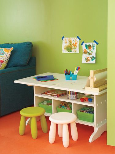 a child's playroom with green walls and white furniture, including stools