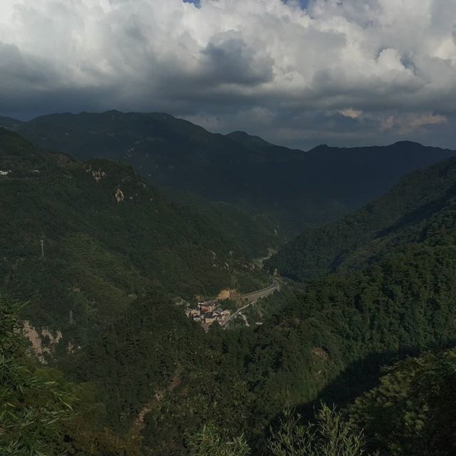 the mountains are covered with green trees and clouds in the sky, while there is no image to describe