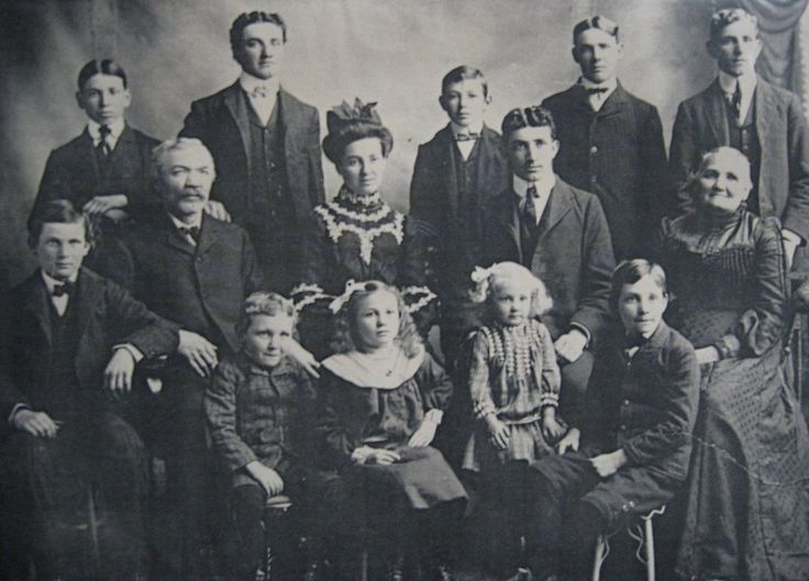 an old black and white photo of a group of people posing for a family portrait