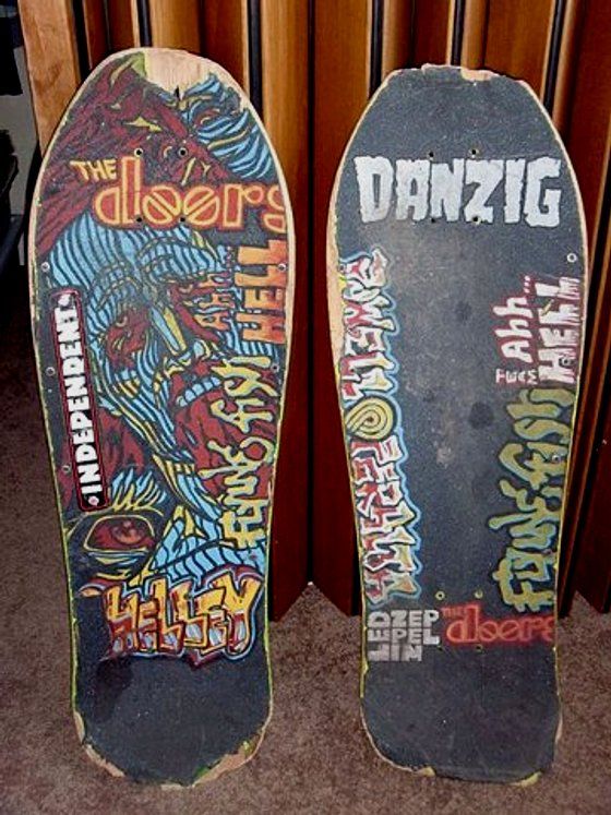 two skateboards with graffiti on them sitting next to each other