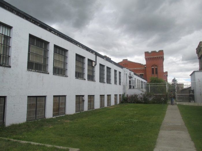 the building is white and has windows on each side, along with a walkway leading up to it