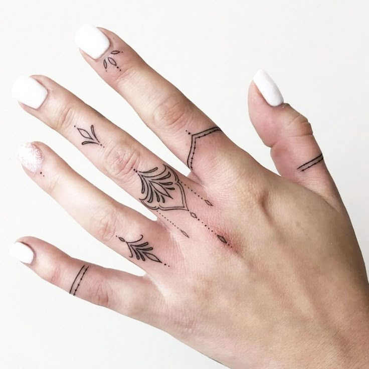 a woman's hand with tattoos on it and a ring in front of her