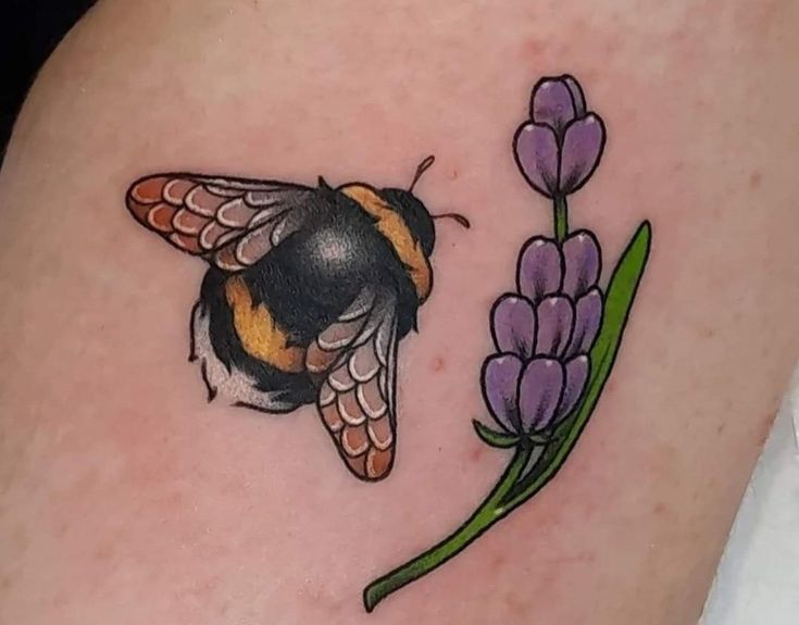 a tattoo with a bee and flowers on it