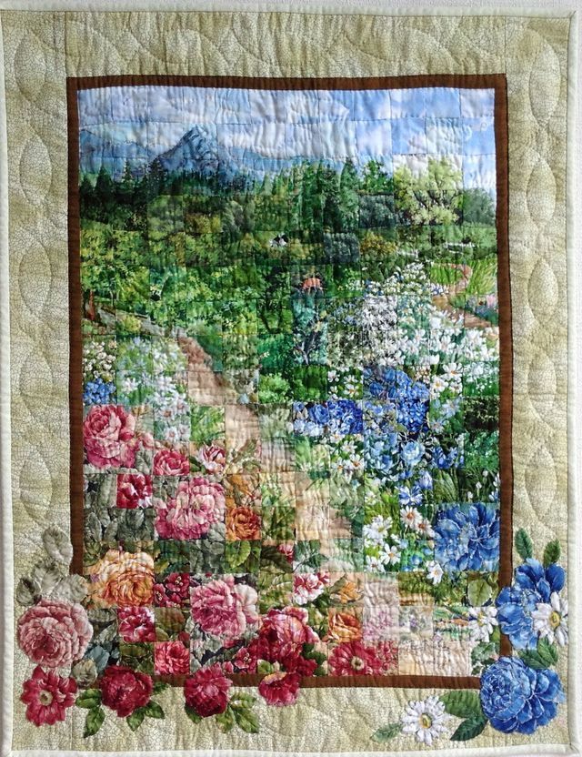 a quilted wall hanging with flowers on it