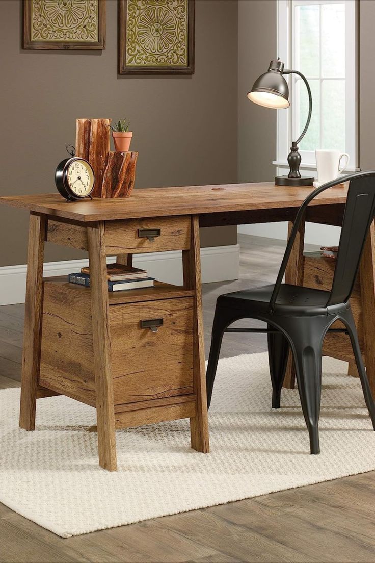 a wooden desk sitting on top of a hard wood floor next to a white rug