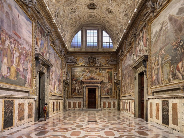 an ornate room with paintings on the walls and floor, along with two doorways