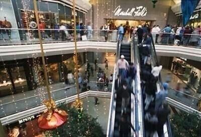 an escalator in a shopping mall with people walking up and down the escalators