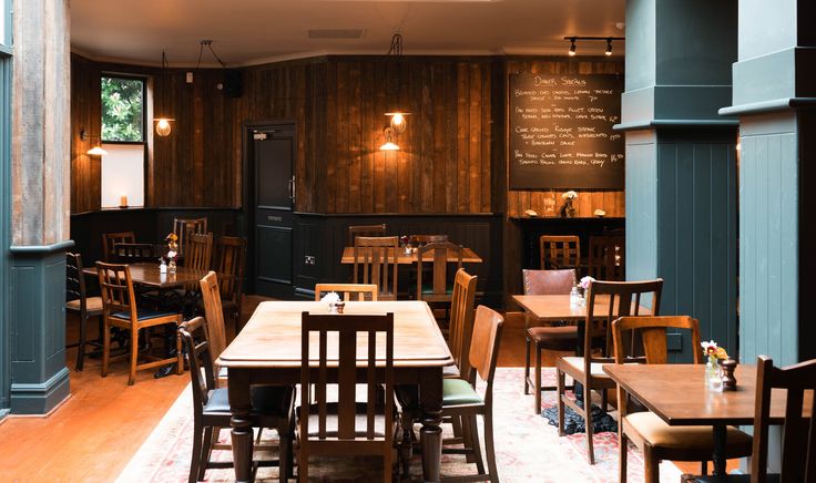 an empty restaurant with wooden tables and chairs