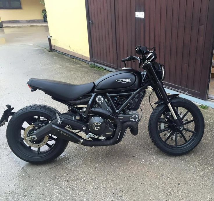 a black motorcycle parked in front of a building