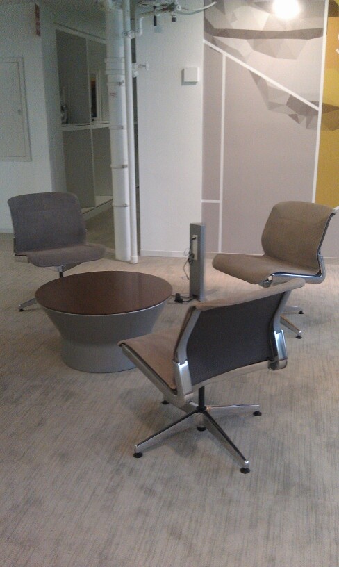 an office area with chairs and a table in the middle, on carpeted flooring