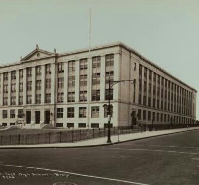 an old black and white photo of a large building on the corner of a street