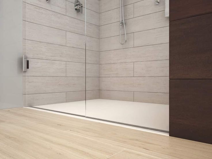 a bathroom with wooden flooring and white tiled walls, along with a walk in shower