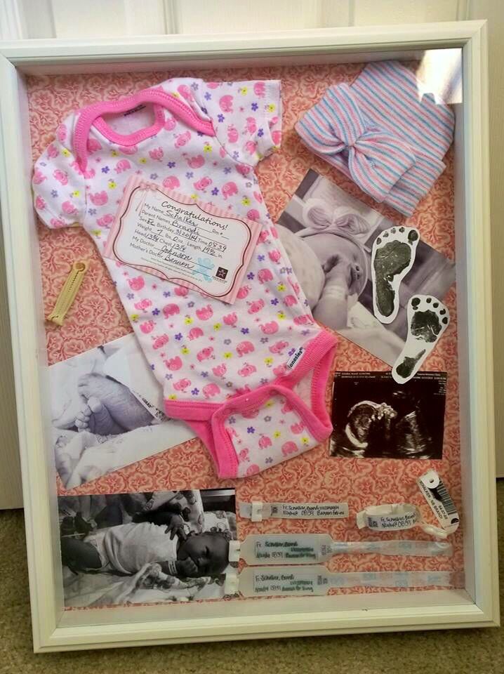 a baby's first year photo in a shadow box with clothes and shoes on it