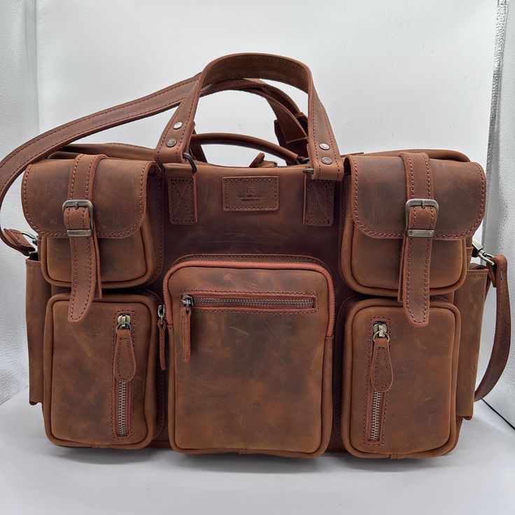 This leather travel bag is perfect for the modern traveler. It's made from high-quality leather that will only get better with age, and it has a spacious interior that can fit everything you need for a weekend getaway or a longer trip. The bag also features a number of pockets and compartments to keep your belongings organized, and it comes with a detachable shoulder strap for comfortable carrying. Features: Made from high-quality leather Spacious interior Multiple pockets and compartments Detac Classic Leather Travel Accessories With Luggage Sleeve, Leather Satchel Luggage For Travel, Classic Satchel Travel Bag For Trips, Classic Leather Travel Bag For Trips, Classic Large Capacity Satchel For Trip, Brown Travel Bag With Top Carry Handle, Classic Leather Satchel For Trip, Classic Leather Travel Bag, Brown Business Weekender Bag With Luggage Sleeve