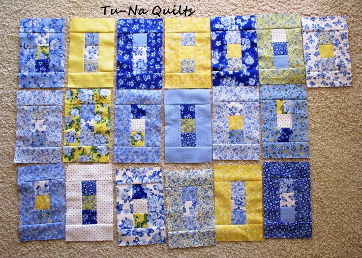 blue and yellow quilts are arranged on the floor, with one block in the middle