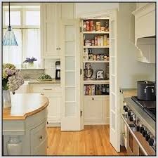 an open pantry in the middle of a kitchen with white cabinets and wood flooring