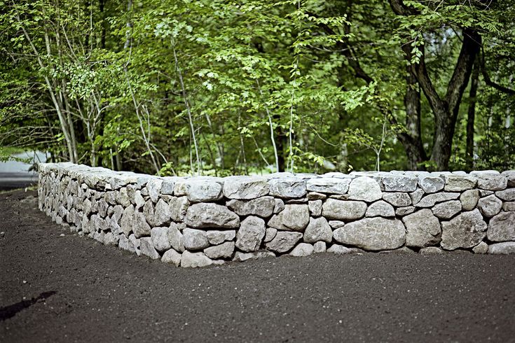 a stone wall with trees in the background