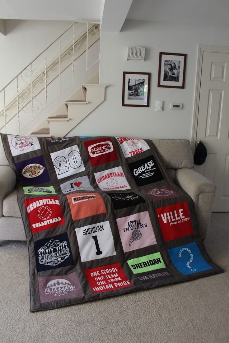 a living room with a couch and a blanket on the floor in front of a stair case