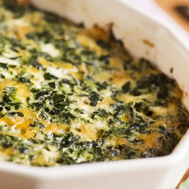 a casserole dish filled with spinach and cheese