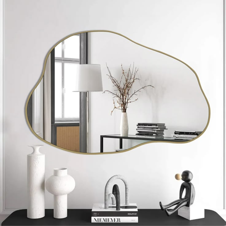 a mirror sitting on top of a table next to a vase