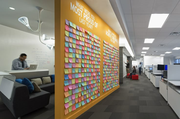 an office cubicle with sticky notes on the wall