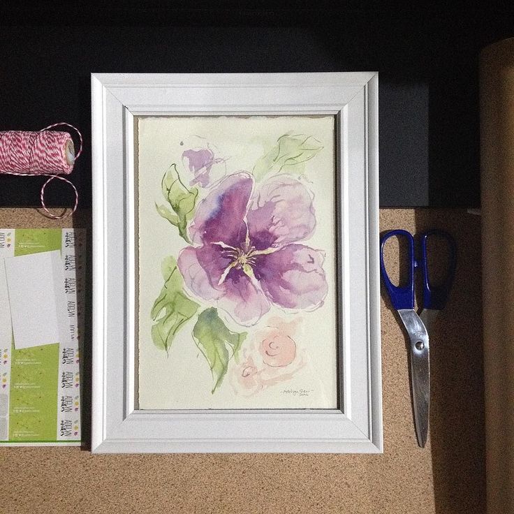 a watercolor painting on paper with scissors next to it and other crafting supplies