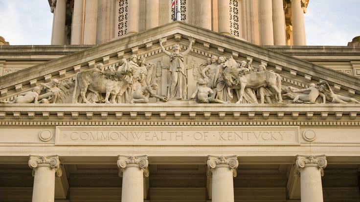 the top of a building with statues on it's sides and columns in front