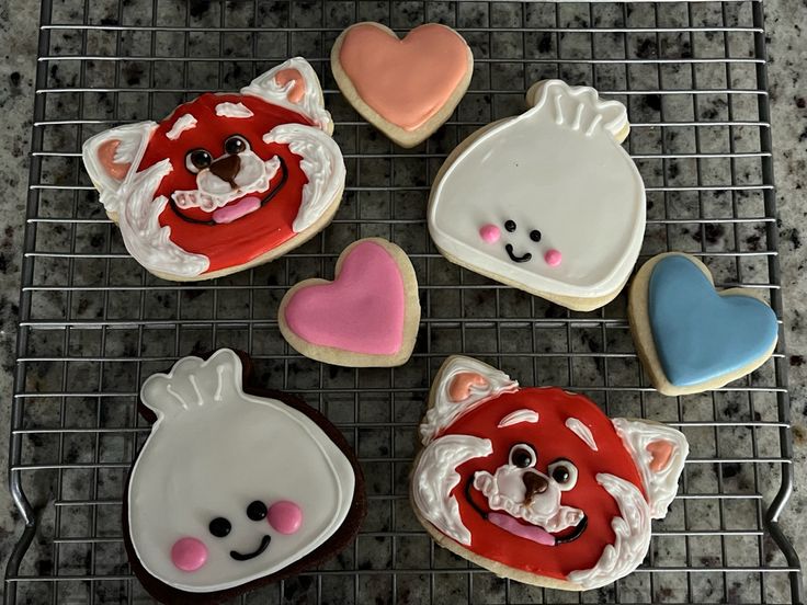 four decorated cookies sitting on top of a cooling rack