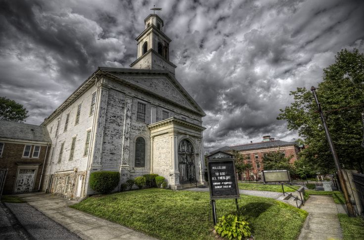 an old church with a cloudy sky in the background