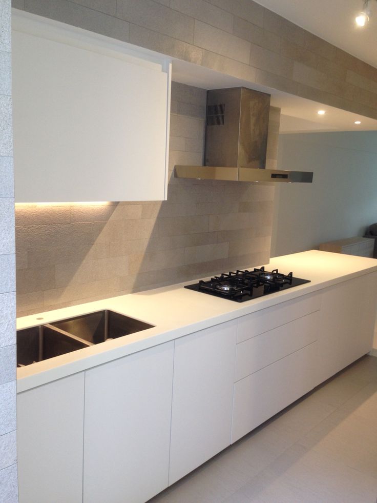 a modern kitchen with white cabinets and counter tops