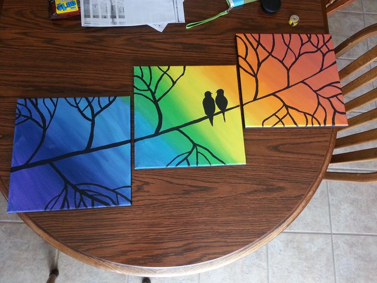 three cards with birds sitting on a tree branch in front of the rainbow colored sky