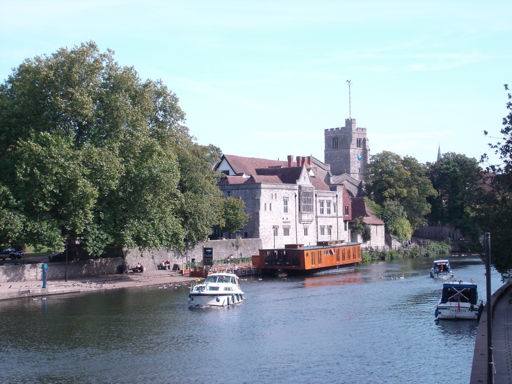 a boat traveling down a river next to tall buildings