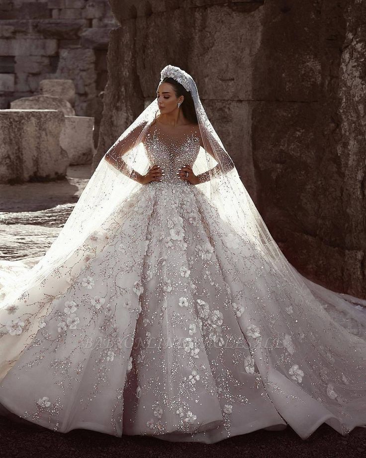 a woman in a wedding dress standing near rocks