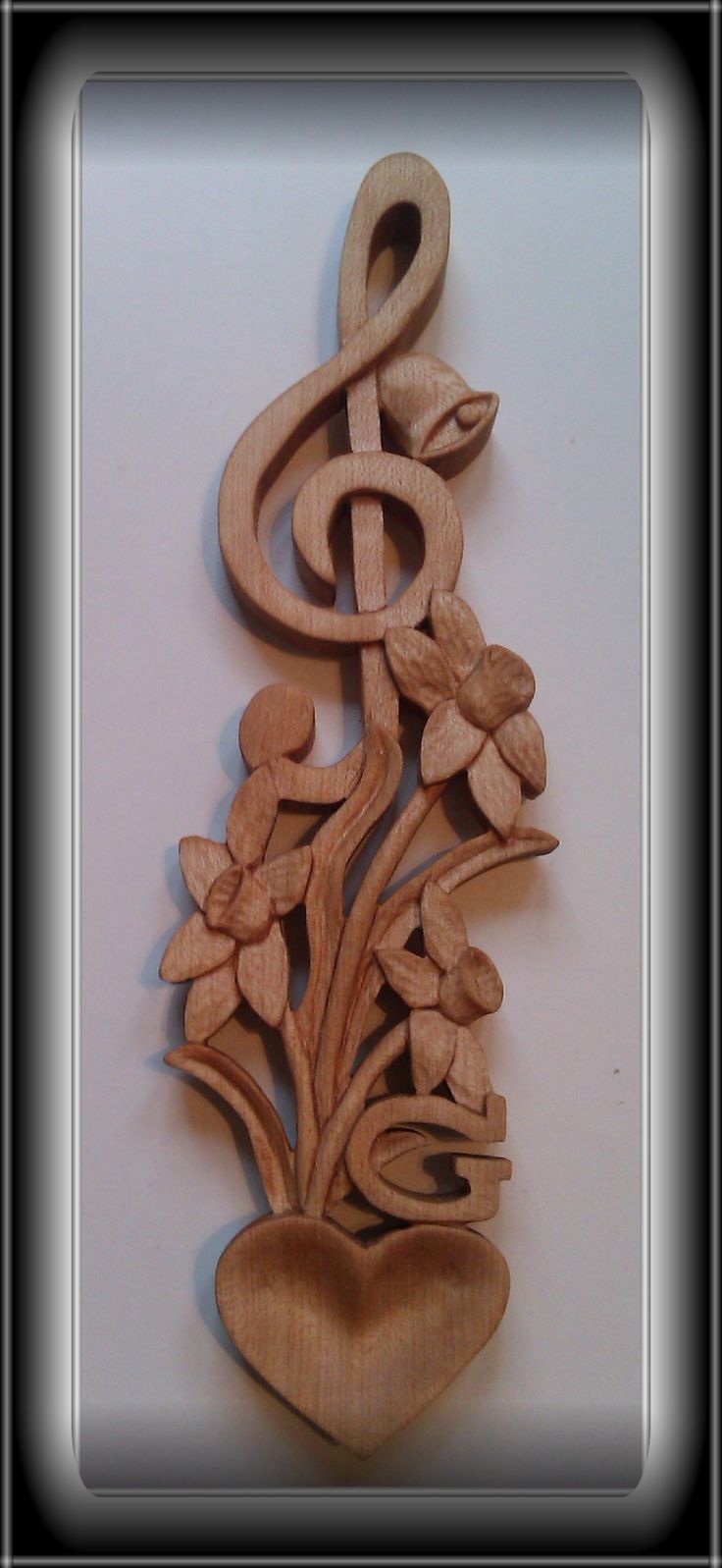 a wooden musical clef with flowers and a heart