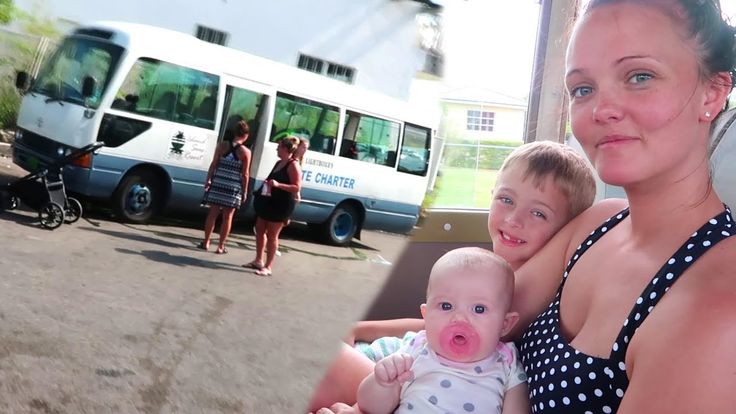 a woman and two children in front of a bus