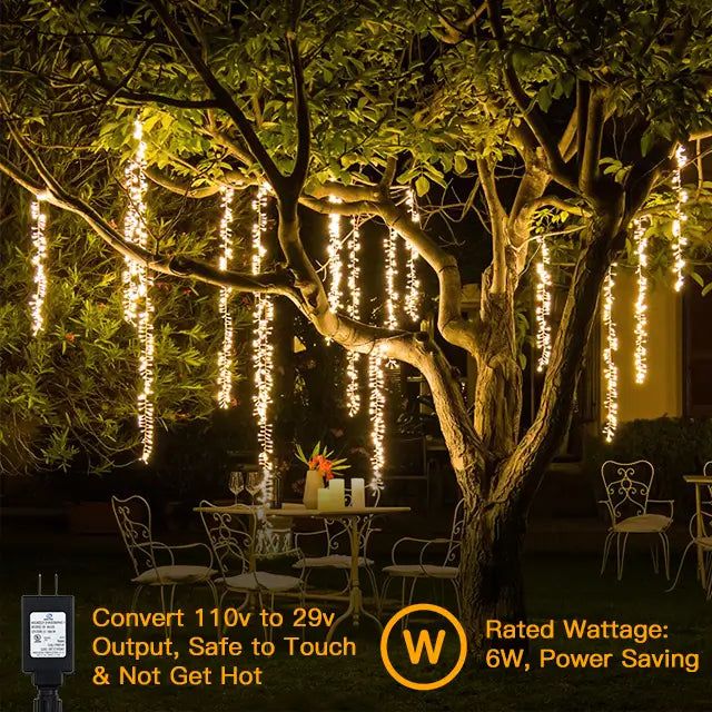 an outdoor table and chairs with lights hanging from the trees