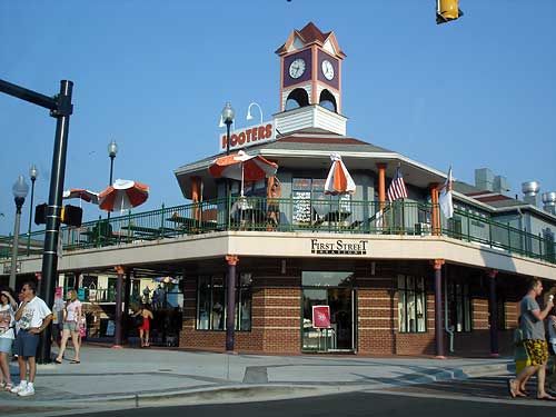 people are walking in front of a building with a clock tower on it's roof